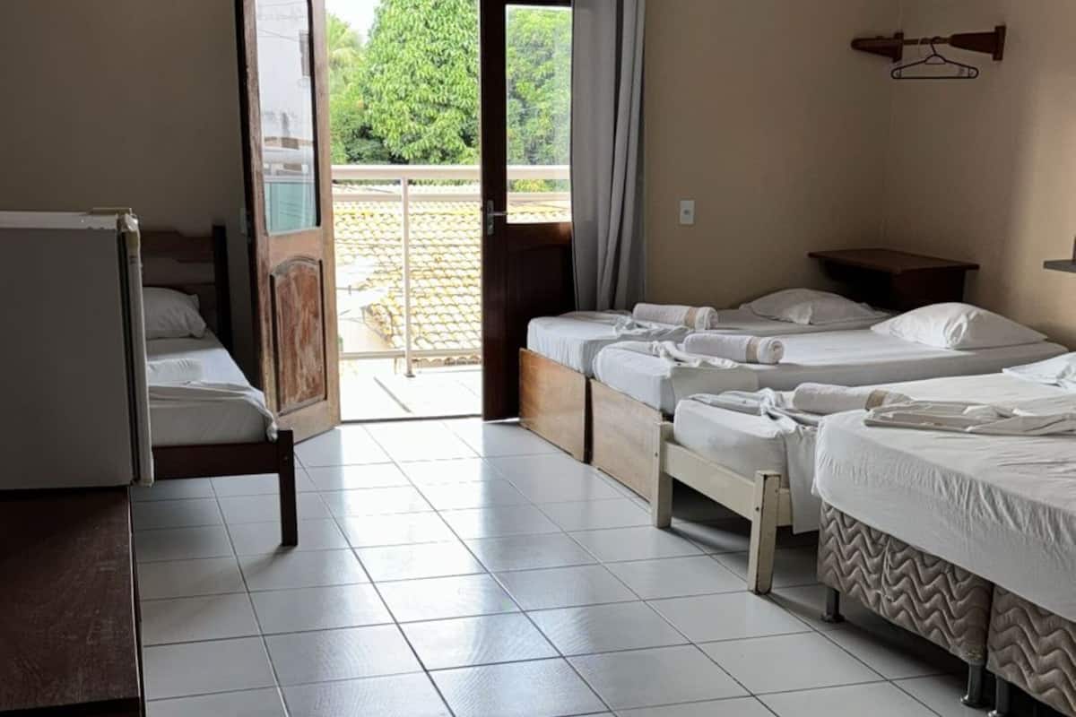 Une chambre d’hôtel avec deux lits, un bureau et une vue sur l’extérieur.