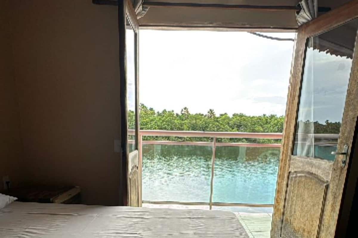 Une chambre d’hôtel avec un lit, une serviette et une vue sur une piscine.