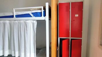 A room with a bunk bed, a wooden door, and red lockers.