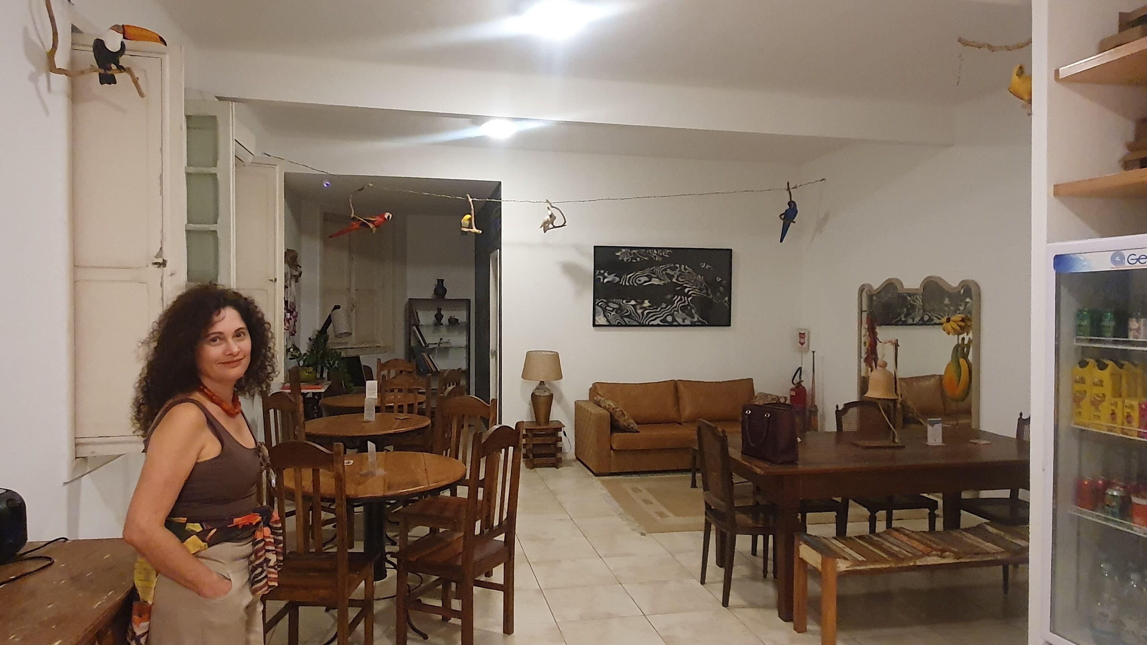 Una sala de estar con sofá, mesa de comedor, sillas y refrigerador.