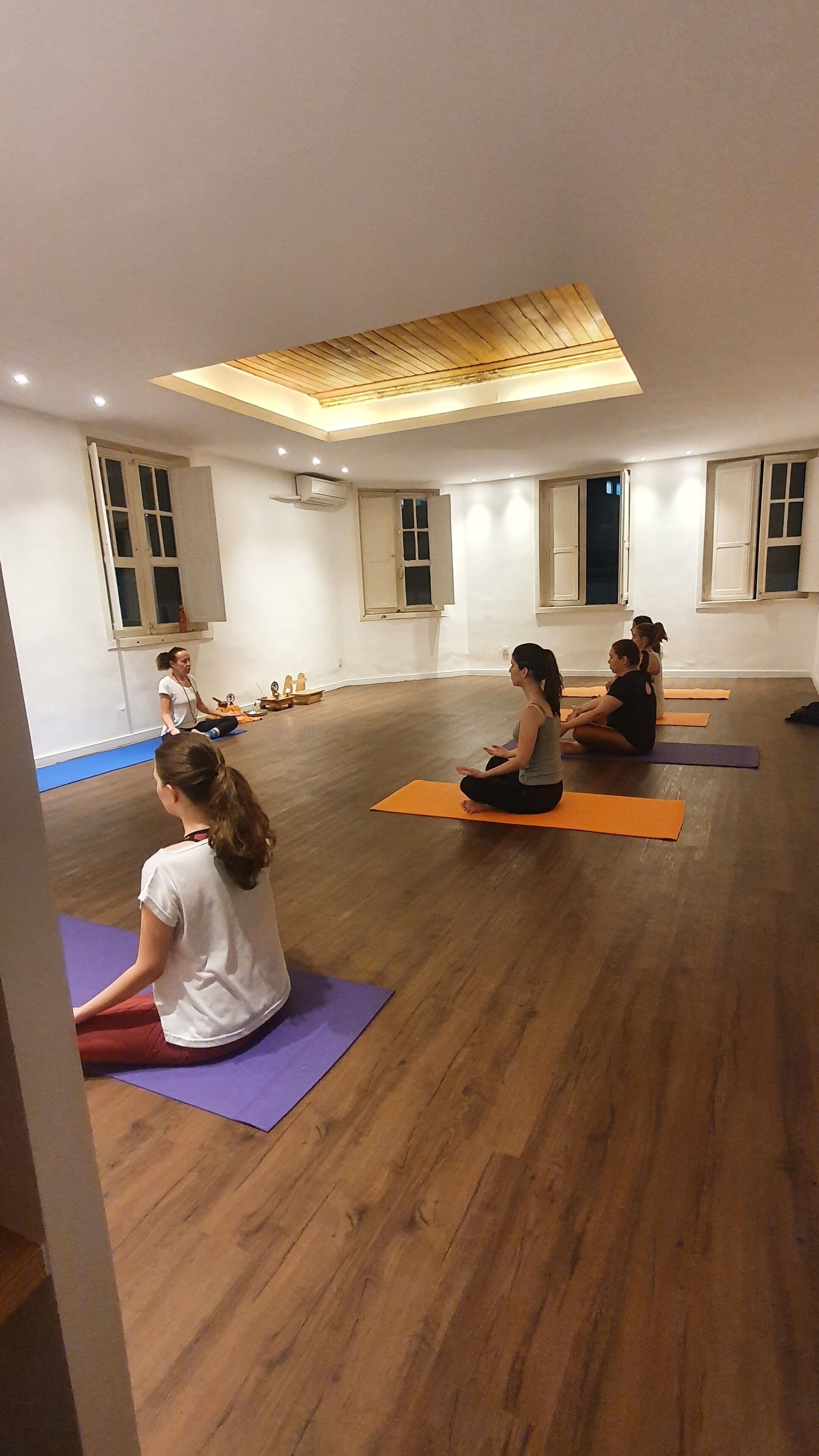 Un studio de yoga doté de planchers en bois et d’un plafond en pente.