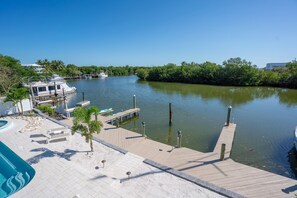 A marina with docked boats, a wooden pier, and a swimming pool.