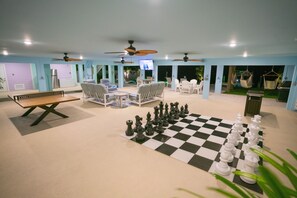 Un vaste espace intérieur doté d’un sol à carreaux, d’un jeu d’échecs et de plusieurs coins salon.
