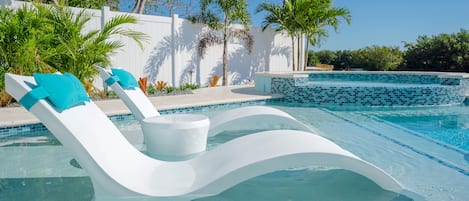 A swimming pool with a white lounge chair and a bucket.