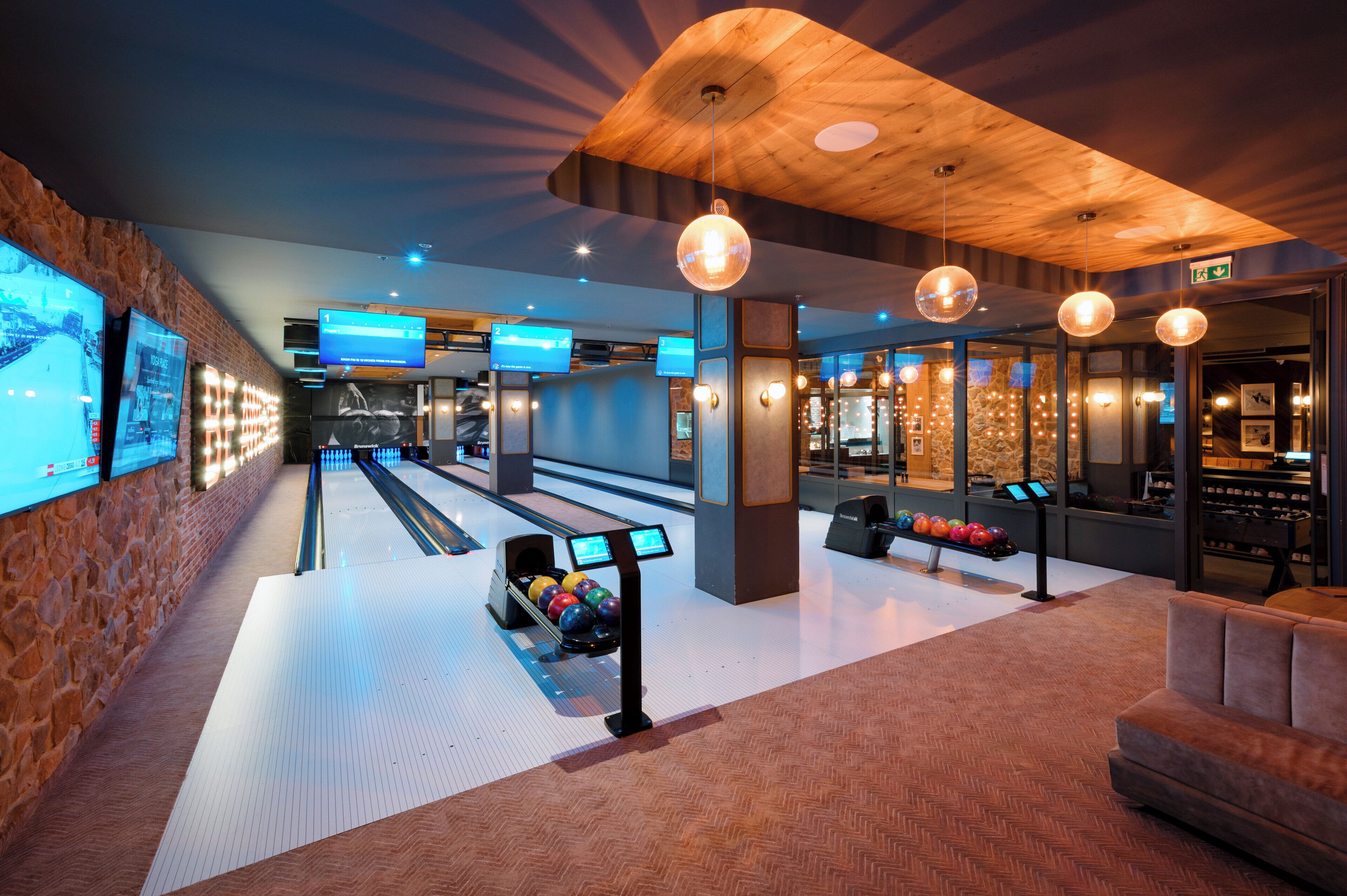 Una bolera con múltiples pistas, zona de estar y bar de aperitivos.