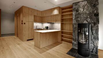 A modern kitchen with wooden cabinetry, a marble countertop, and a built-in stone wall.