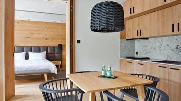 Eine moderne Küche mit Holzschränken, einer Marmorarbeitsplatte und einem Essbereich mit Holztisch und -stühlen.
