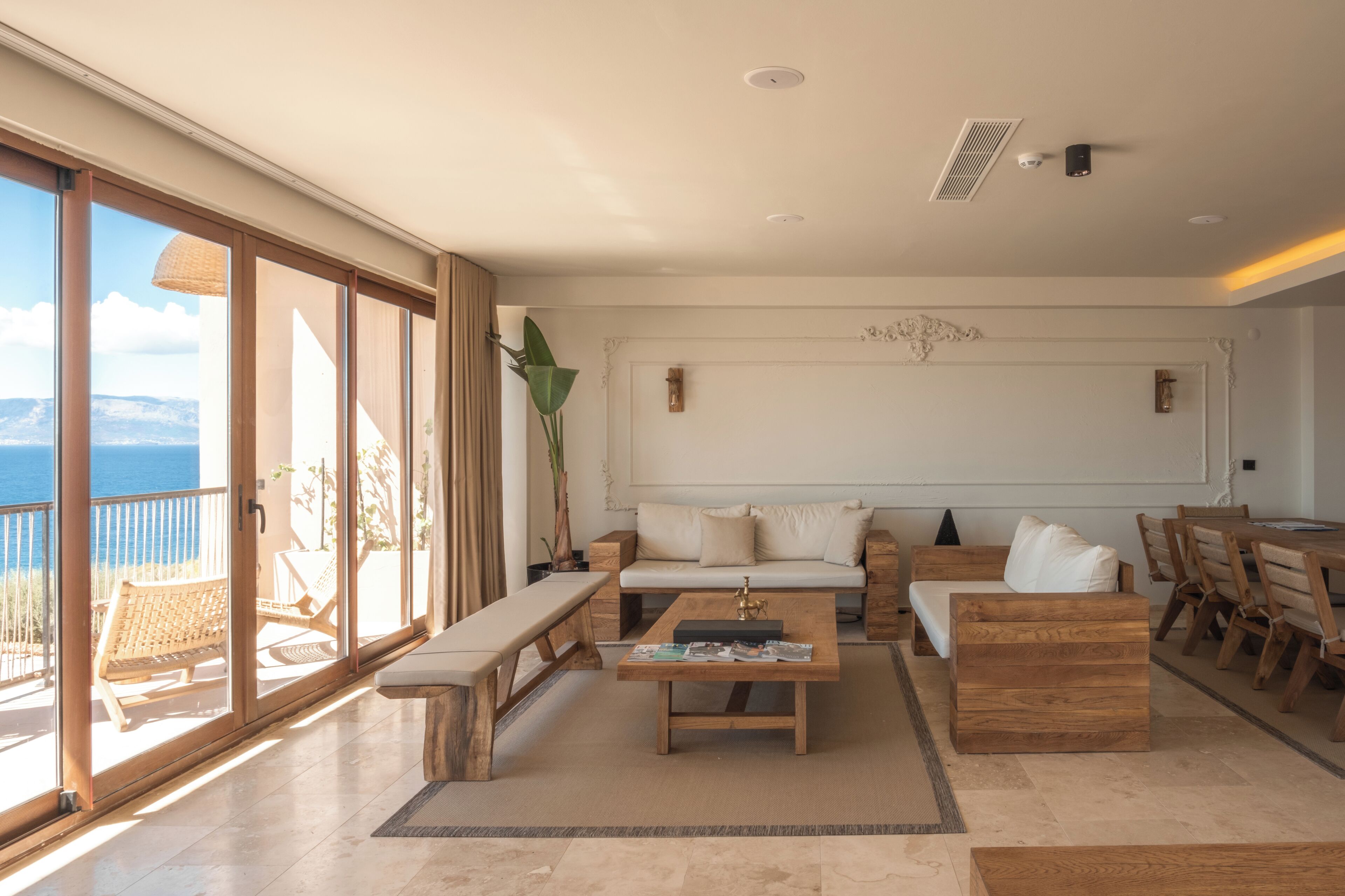 A spacious living area with a sofa set, a coffee table, and a dining table with chairs.