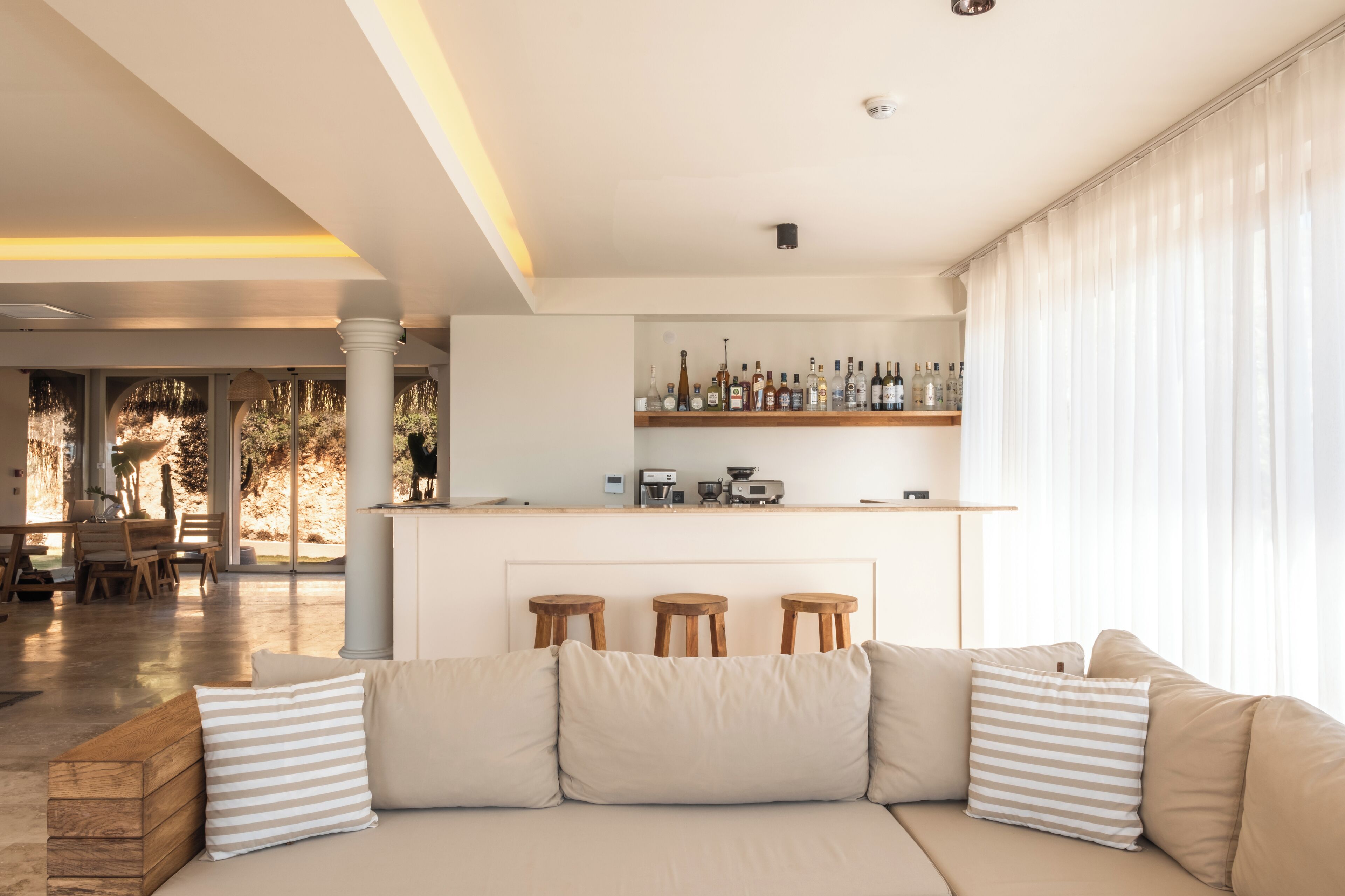 A modern living room with a sofa, a coffee table, and a bar area with stools.