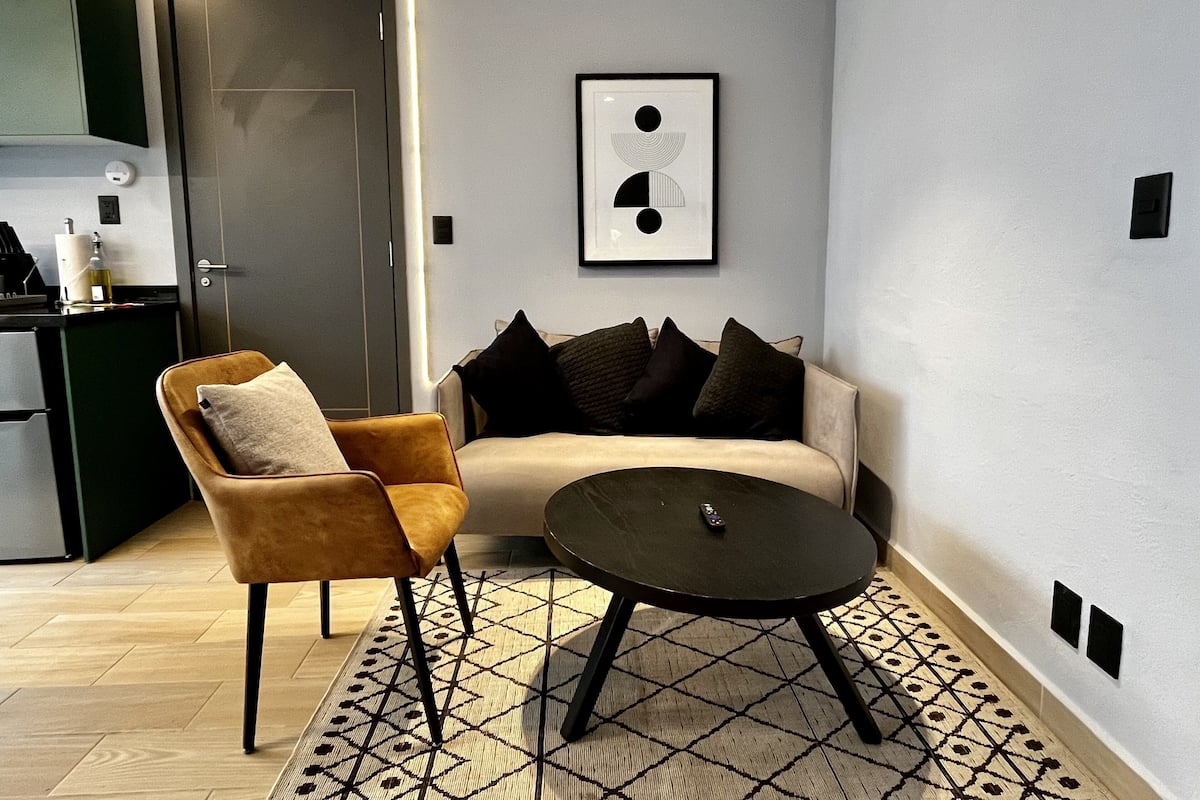 Ein modernes Wohnzimmer mit Sofa, Sessel und Couchtisch.