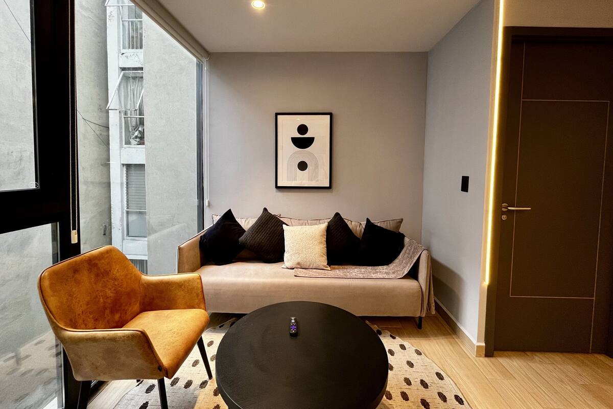 Ein modernes Wohnzimmer mit einer Couch, einem Sessel und einem Couchtisch.