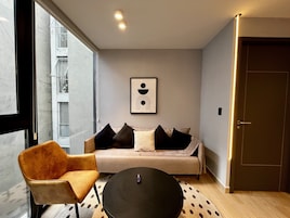 Una sala moderna con un sofá, una silla y una mesa de centro.