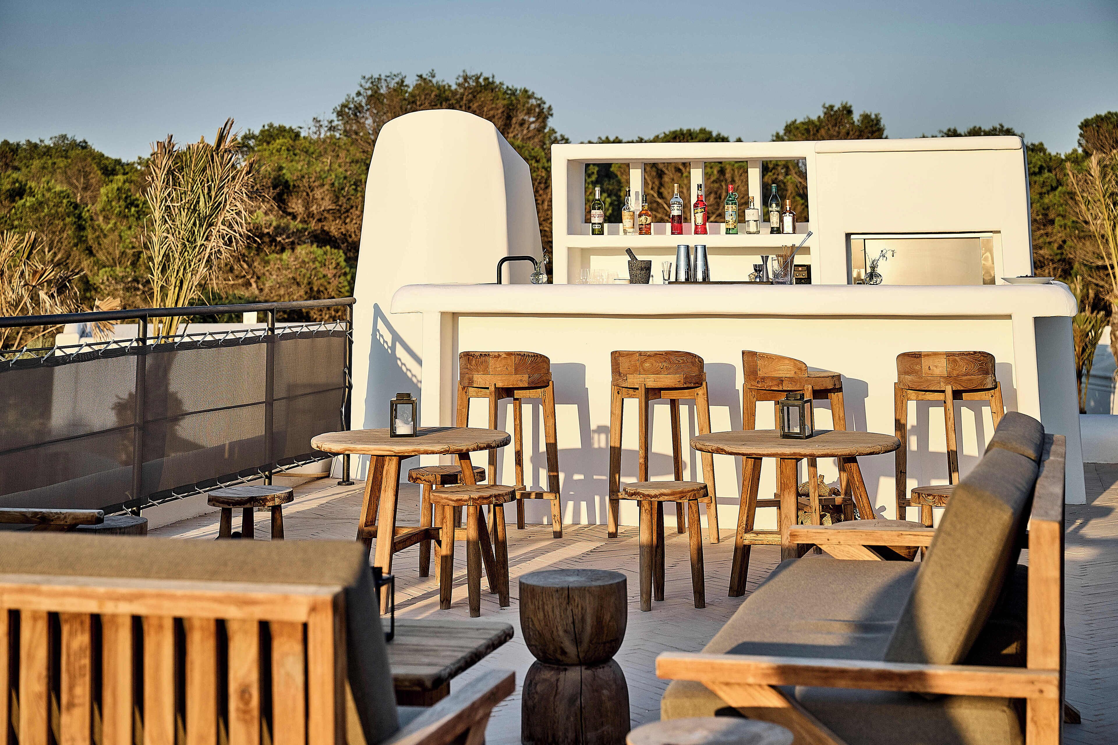 An outdoor seating area with wooden furniture and a bar.