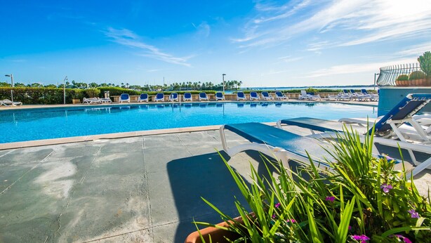 A swimming pool with lounge chairs and a clear sky.