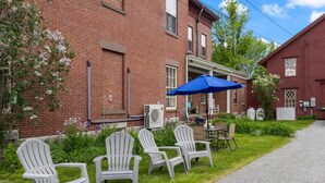 A brick building with outdoor seating and a blue umbrella.
