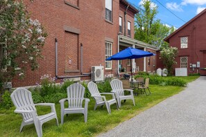 A brick building with outdoor seating and a blue umbrella.