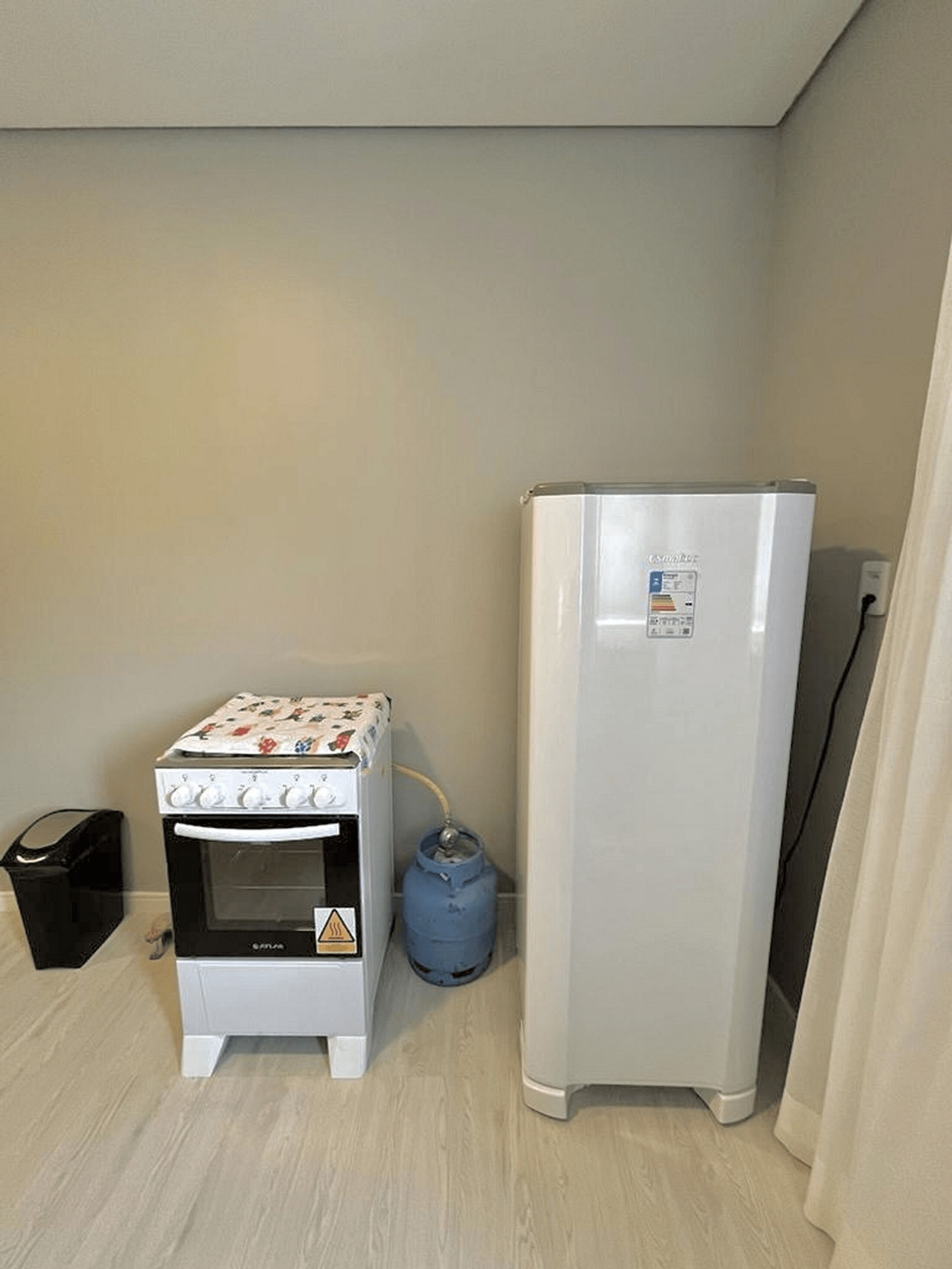 A kitchenette with a small oven, a refrigerator, and a water dispenser.