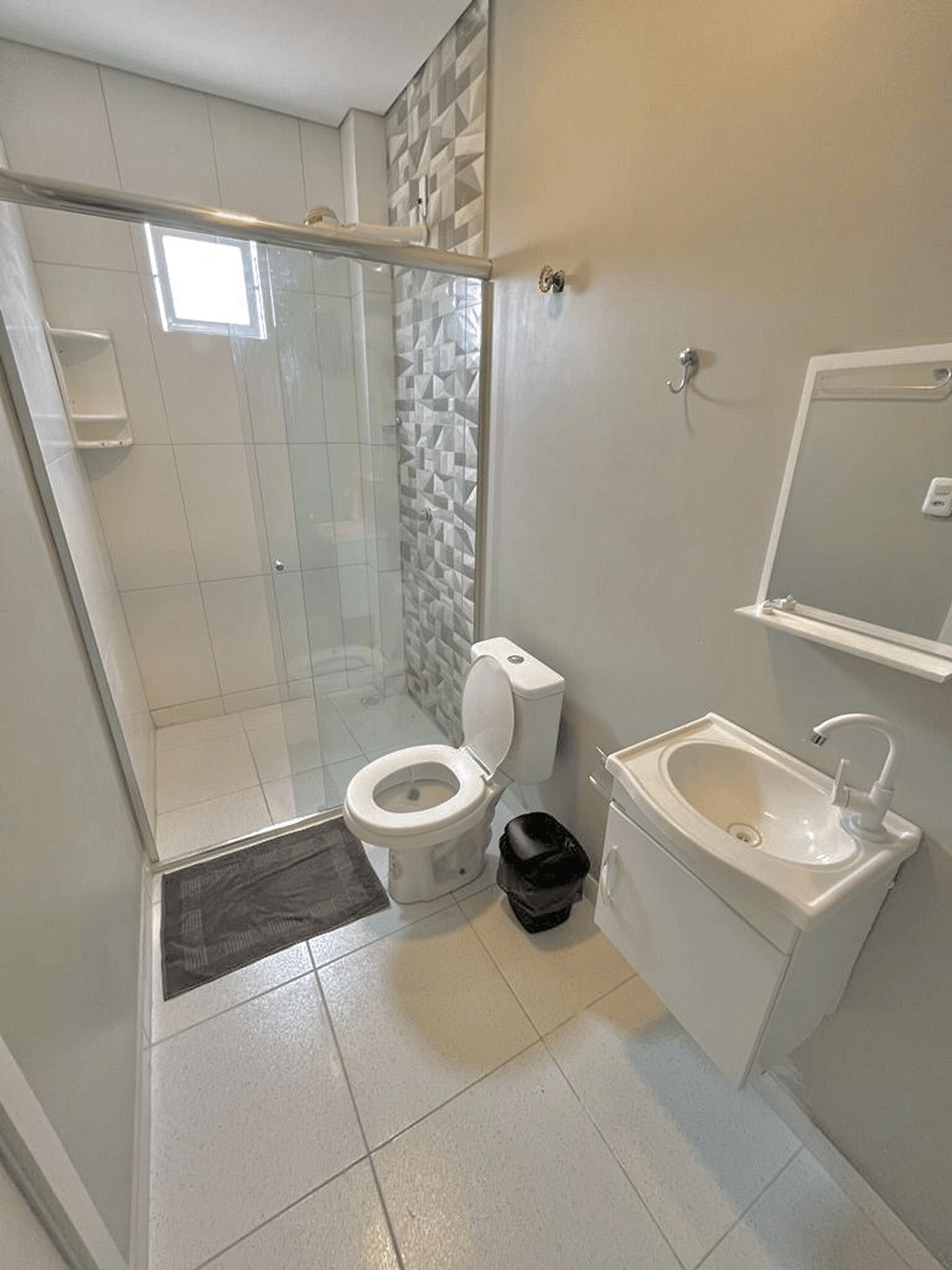 Un baño con inodoro, lavamanos y ducha.