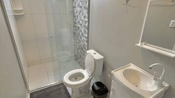 Un baño con inodoro, lavamanos y ducha.