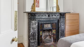 A room with a fireplace, wooden cabinet, and patterned rug.