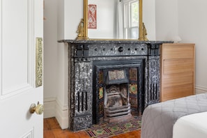 A room with a fireplace, wooden cabinet, and patterned rug.
