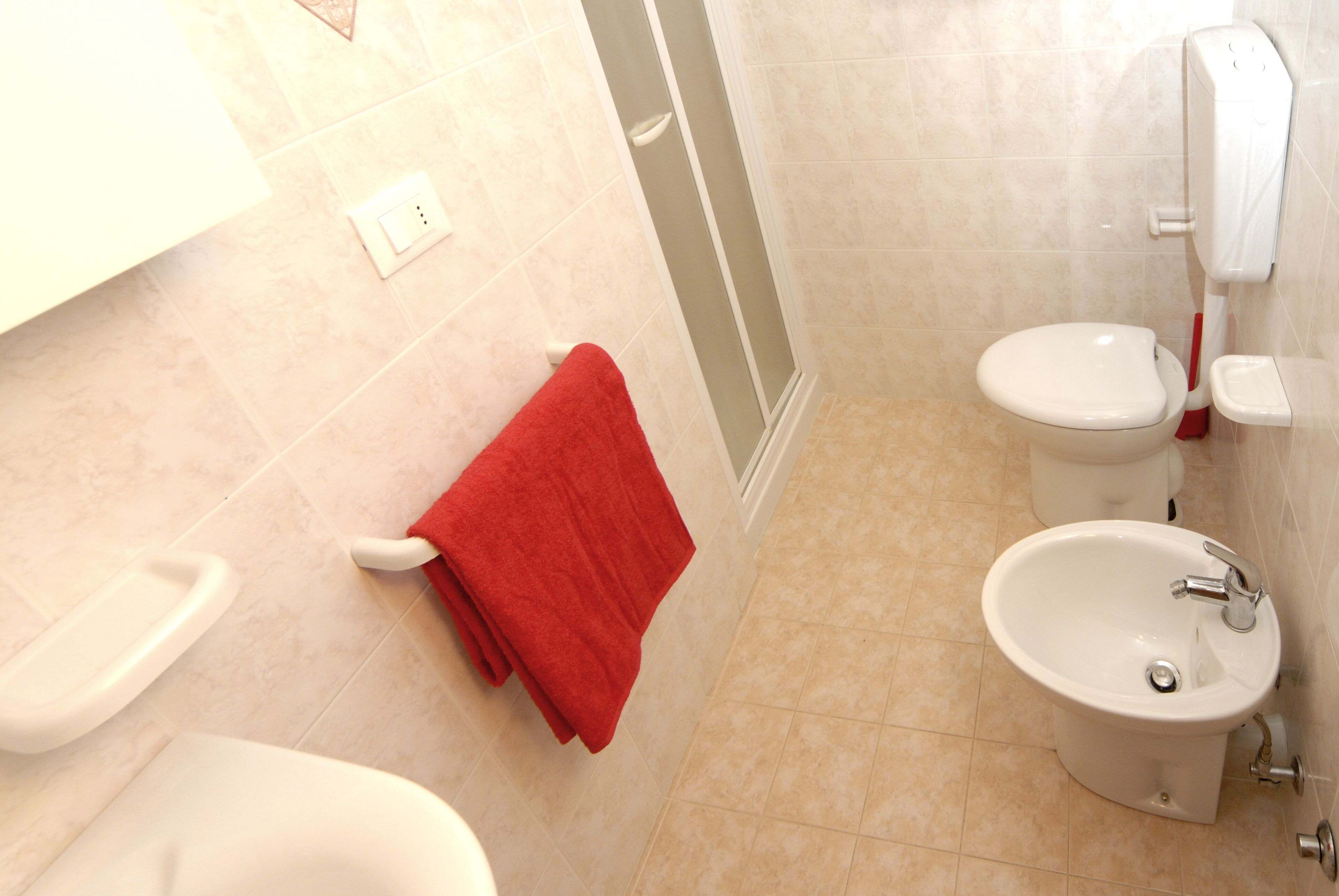A bathroom with a toilet, bidet, and sink.