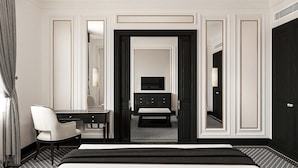 Una habitación de hotel con cama, escritorio, silla, cómoda y espejo.