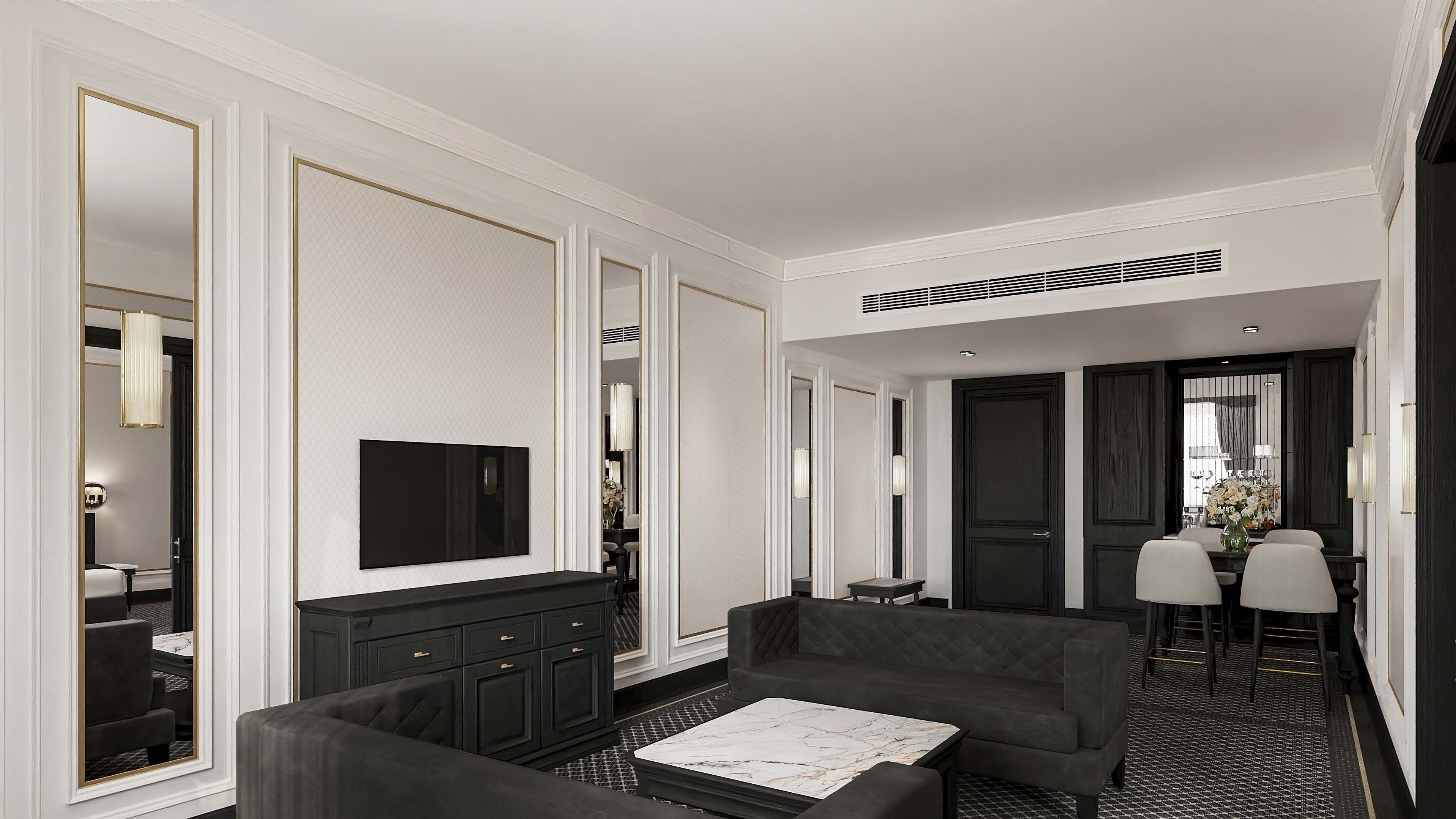 Un moderno vestíbulo de hotel con una paleta de colores blanco y negro, que presenta un área de descanso con sofás y una mesa de centro, un televisor montado en la pared y un comedor con una mesa y sillas.