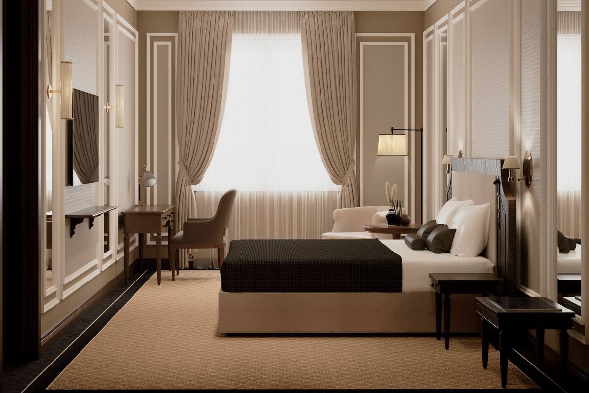 Une chambre d’hôtel avec un grand lit, un bureau, une chaise, une table de chevet et une fenêtre avec des rideaux.