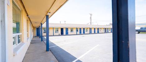 A motel with a covered walkway and a parking lot.