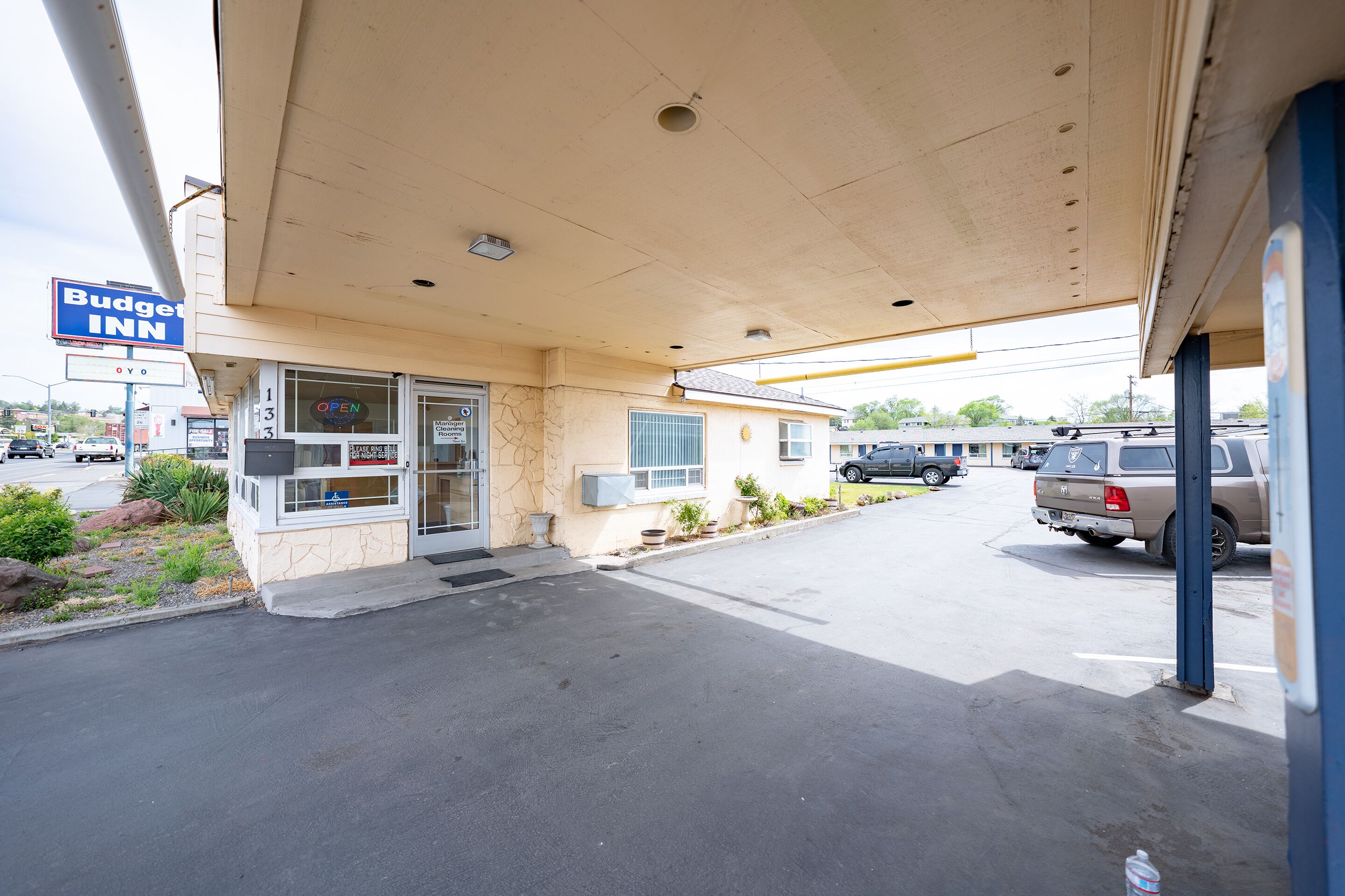 A Budget Inn with a clear entrance, a visible sign, and a parking area with a truck.