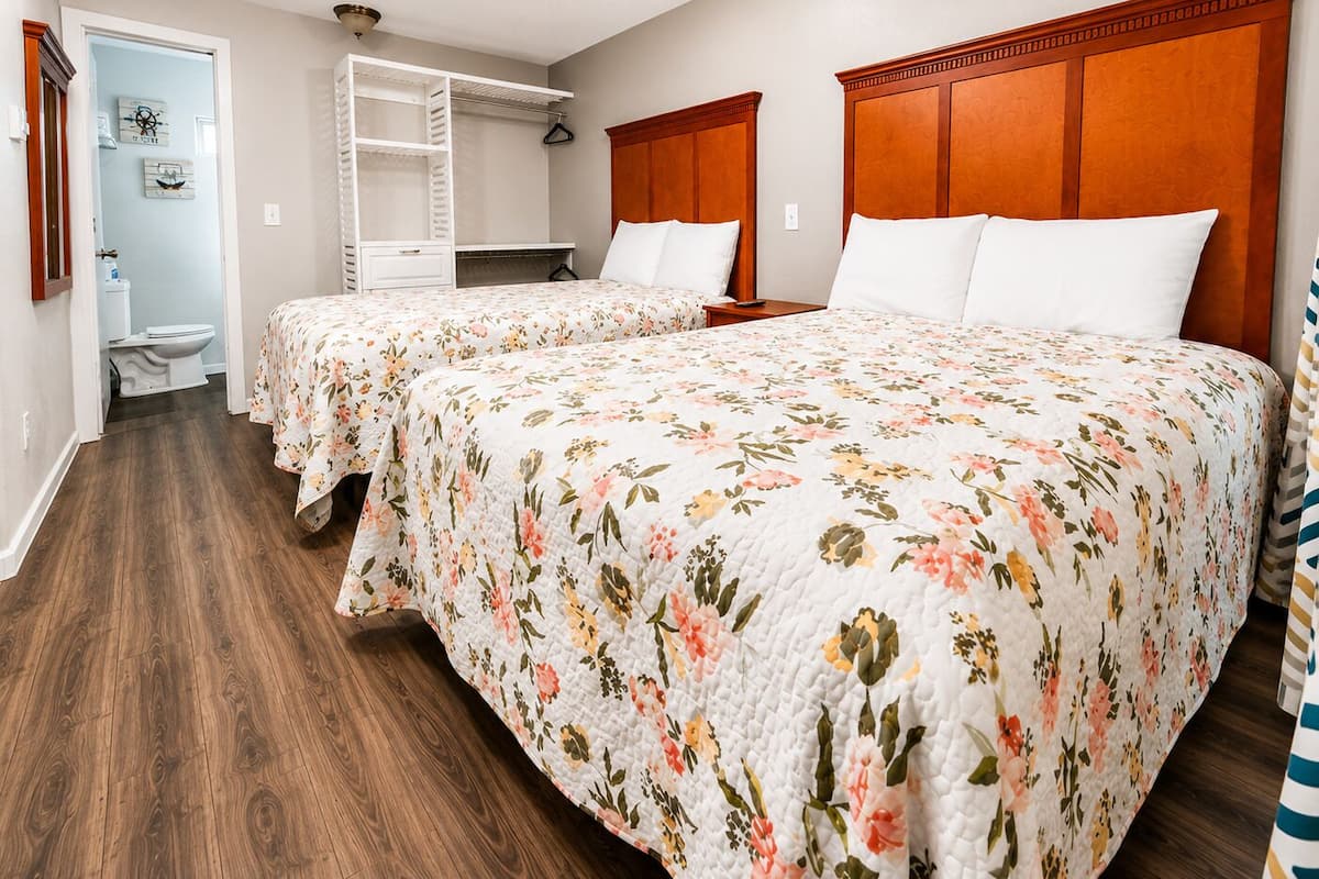 A bedroom with two beds, a walk-in closet, and a bathroom.
