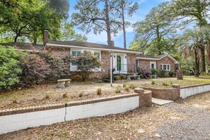 A brick house with a front porch, a mailbox, and a well-maintained garden. - Spacious 4br/3ba Park Circle Home. Great Location! (North Charleston)