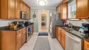 A kitchen with wooden cabinets, stainless steel appliances, and a tiled floor. - Spacious 4br/3ba Park Circle Home. Great Location! (North Charleston)