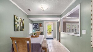 A dining area with a table set for two, a chandelier, and a view through a window. - Spacious 4br/3ba Park Circle Home. Great Location! (North Charleston)
