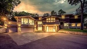 A modern two-story house with a garage, large windows, and a stone facade.