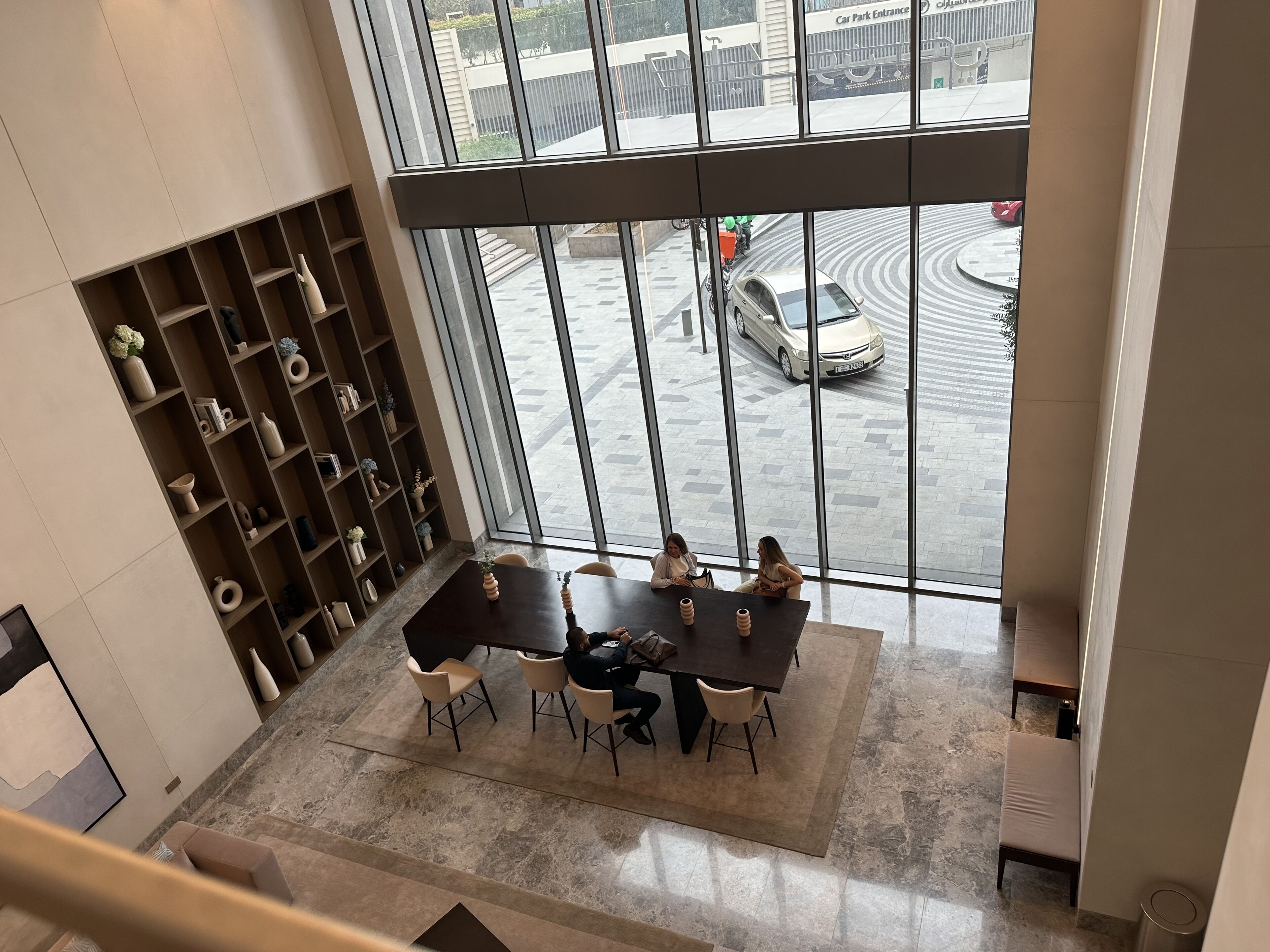 A modern interior with a large window overlooking a parking area.