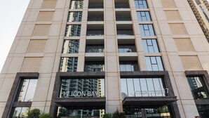 A tall building with a modern facade, a prominent entrance, and a sign reading "17 ICON BAYH".