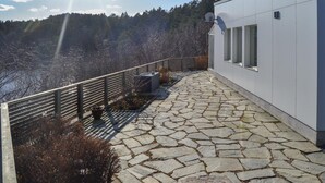 Un vialetto in pietra con ringhiera metallica che conduce a un edificio moderno con ampie finestre.