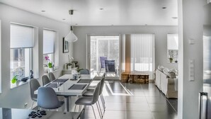Un'elegante sala da pranzo con un tavolo lungo, sedie e vista sull'esterno.