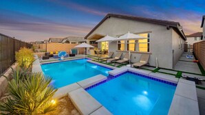 A backyard with a swimming pool, lounge chairs, and a patio area. - New Large Home-Views-Mountain, Lake & Golf (Indio)