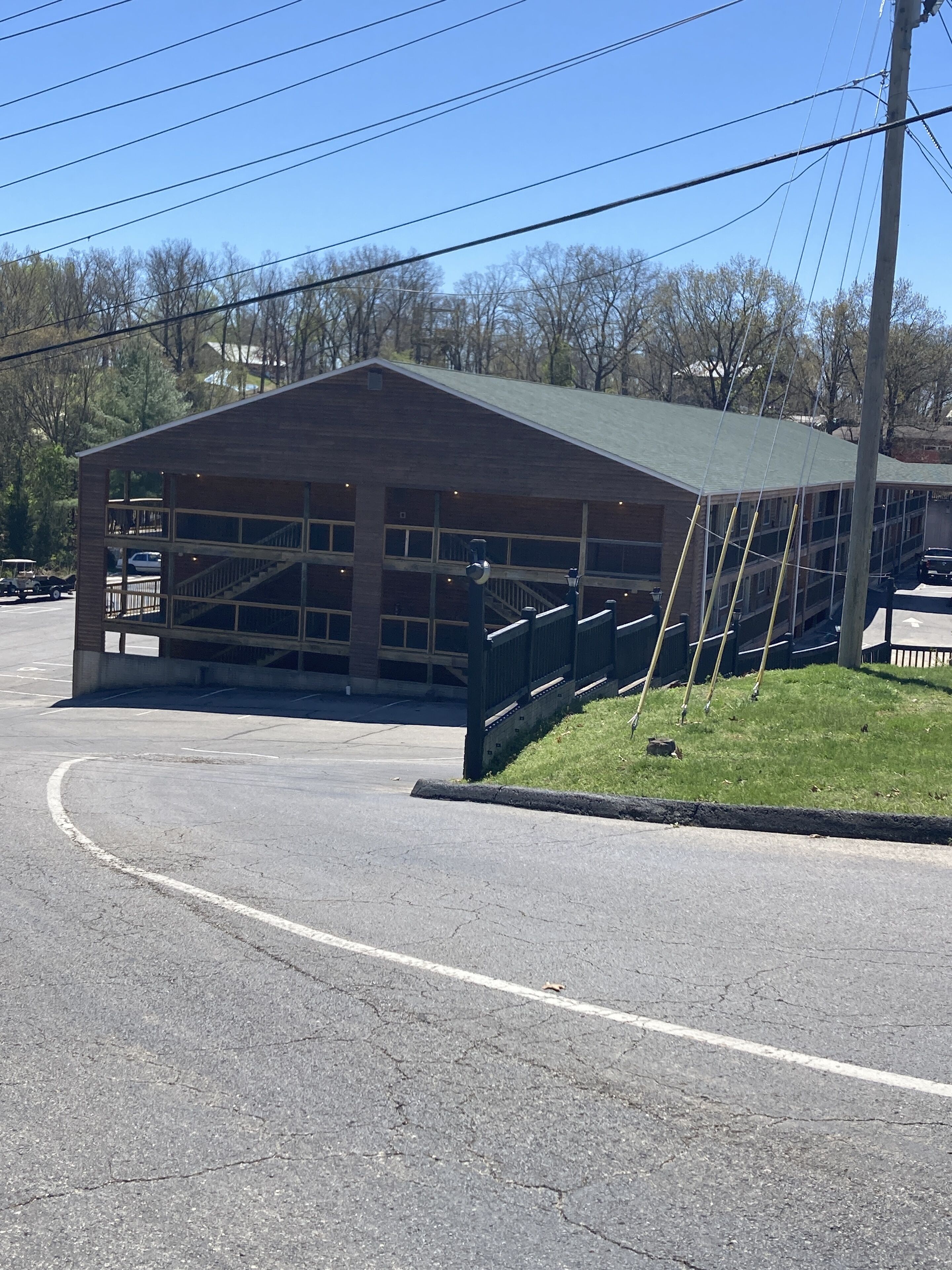 A building with a covered parking area and a staircase leading to the entrance.
