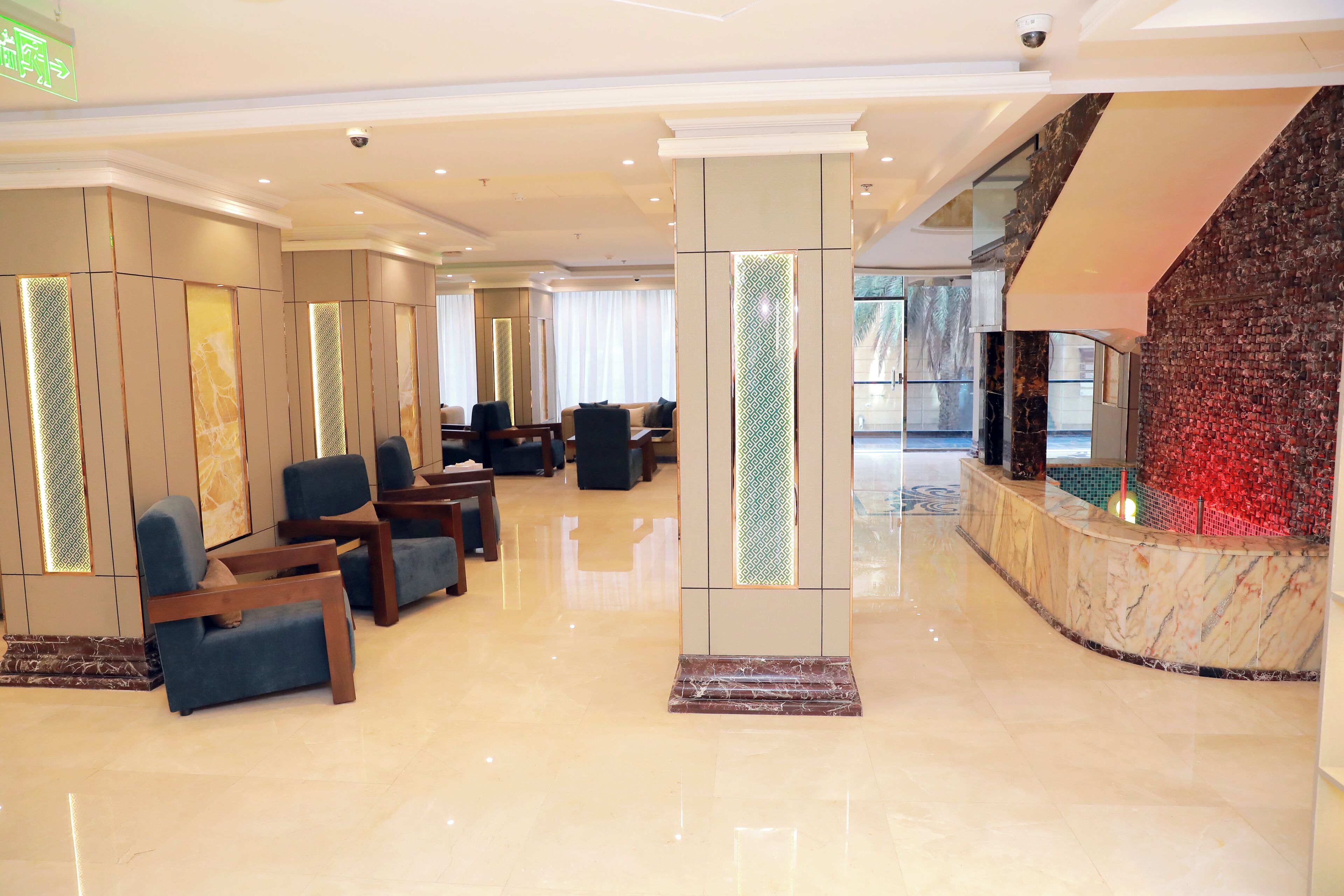 A modern lobby with seating areas, a reception desk, and a large screen.
