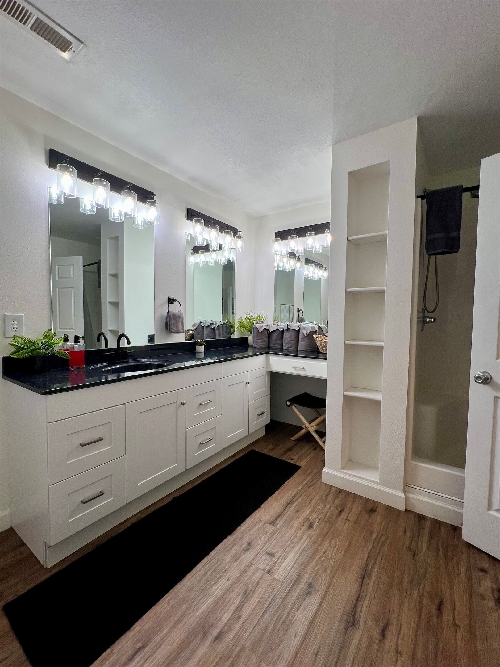 A modern bathroom with a large vanity, double sinks, and a walk-in shower.