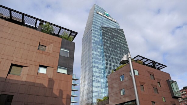 Un edificio moderno con fachada de vidrio y un cartel que dice 'BNF PARIBAS'.