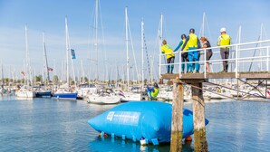 A marina with multiple boats docked, a large inflatable structure, and people on a dock. - RBR 1747 - Beach Resort Kamperland (Kamperland)