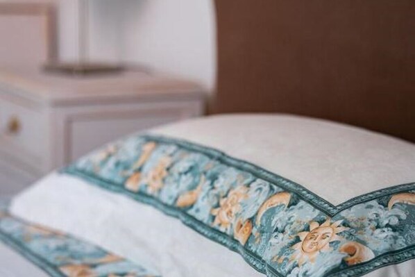 A plush bed features a decorative pillow with a floral pattern.