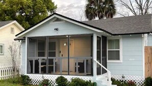 A single-story house with a covered porch, a white picket fence, and a small garden area. - Comfortable new 2- bedroom house (Jacksonville)