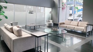 A modern lobby with a sofa, armchairs, and a coffee table.
