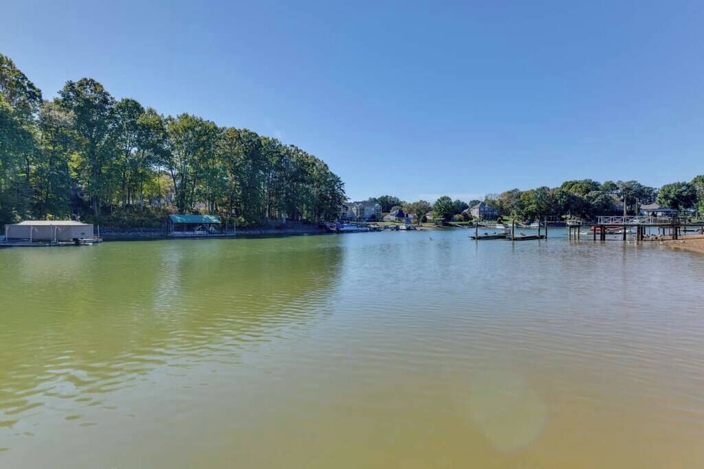 A calm lake with a dock and a covered area on the left.